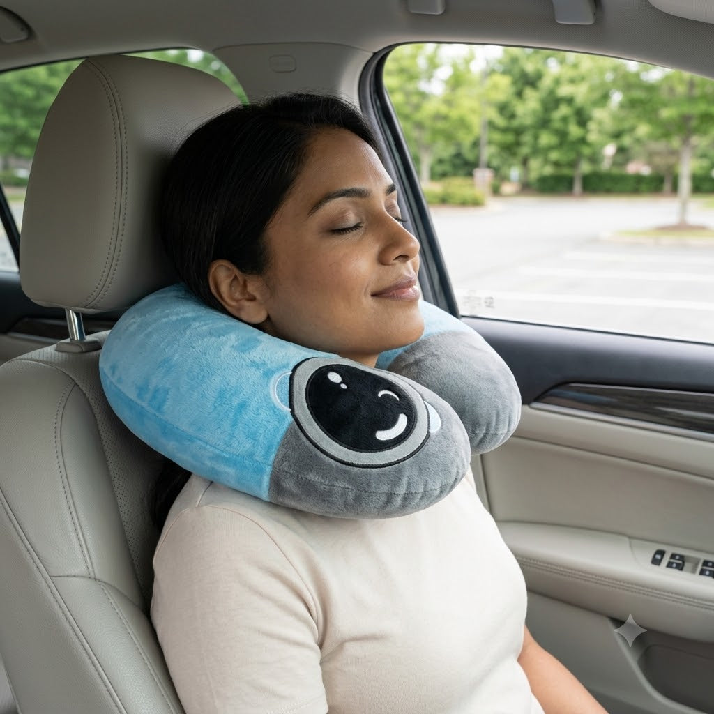 Two-tone light blue and dark grey plush U-shaped travel neck pillow with embroidered winking cartoon face patch